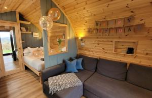 a living room with a couch and a bed at Odli Glamping - Luxury Glamping Pod in Welshpool