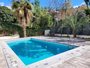 a swimming pool with blue water in a yard at "COZY LOFT", TERRACE, PARKING and SWIMMING POOL in Málaga