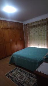 a bedroom with a bed and some wooden cabinets at Casa da Cândida in Nazaré