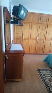 a room with a tv and wooden cabinets at Casa da Cândida in Nazaré