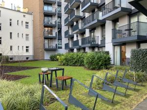 a park with tables and chairs in front of a building at Flatbook - City Center Apartments Chlebova with Gym in Gdańsk