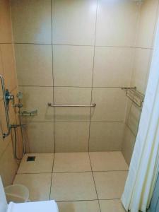 een douche met een glazen deur in de badkamer bij Pearlspot Hotel in Kumarakom