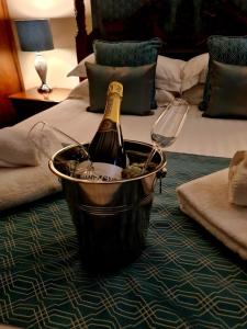 a bottle of champagne in a bucket on a bed at The Trewythen in Llanidloes