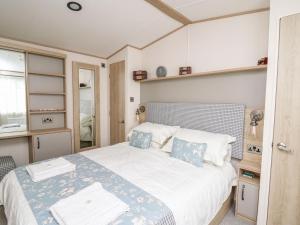 - une chambre avec un grand lit blanc et des oreillers bleus dans l'établissement Balmoral, à Pendine