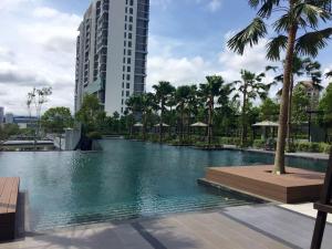 a swimming pool with palm trees and a tall building at Tropicana Avenue B32-09, Petaling Jaya in Petaling Jaya
