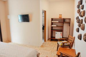 a bedroom with a bed and a table and chairs at Ajubá Pousada in Morro de São Paulo