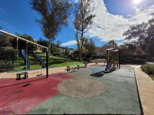 a park with a playground with benches and a slide at "COZY LOFT", TERRACE, PARKING and SWIMMING POOL in Málaga