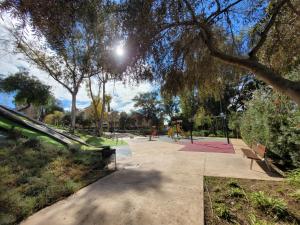 a park with a playground with benches and trees at "COZY LOFT", TERRACE, PARKING and SWIMMING POOL in Málaga