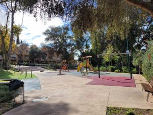 a park with a playground with benches and swings at "COZY LOFT", TERRACE, PARKING and SWIMMING POOL in Málaga