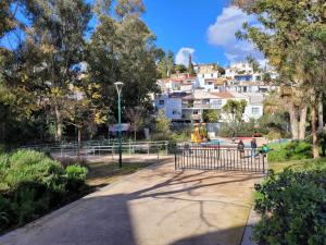 a park with a playground and buildings in the background at "COZY LOFT", TERRACE, PARKING and SWIMMING POOL in Málaga