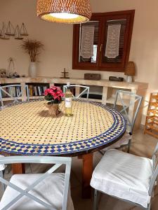 桑塔尼伊的住宿－Villa Sanchez in Strandnähe mit Pool, Jacuzzi, Klima, WiFi, Gas BBQ，一张带蓝白波尔卡圆桌布的餐桌