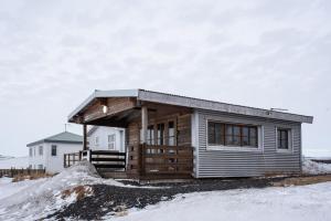 ein Blockhaus im Schnee vor einem Haus in der Unterkunft The Holiday Houses by Stay Iceland in Kirkjubæjarklaustur