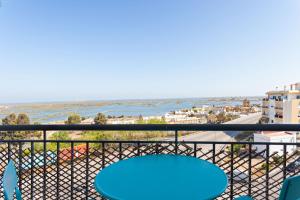 a blue table on a balcony with a view of the ocean at Formosa View in Faro