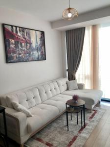 een woonkamer met een witte bank en een tafel bij Secured Lux 1 + 1 apartment - Gym, Sauna & Parking ( EMP 142 ) in Esenyurt