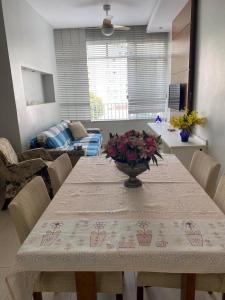 una mesa de comedor con un jarrón de flores. en Luxo apartamento In Copacabana, en Río de Janeiro