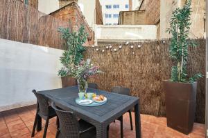 une table noire avec une assiette de nourriture sur une terrasse dans l'établissement BBarcelona Clot Apartments, à Barcelone