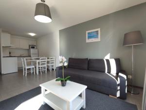 een woonkamer met een bank en een tafel bij Le Romarin - Climatisation piscine & parking privé in Gréoux-les-Bains