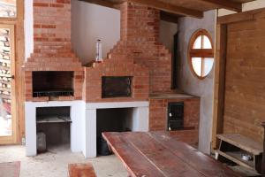 a brick fireplace with a wooden table in a room at Brigigyop in Lunca de Sus