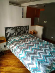 um quarto com uma cama com um edredão colorido em Departamento Unico en Recoleta !! Ubicacion Excelente. em Buenos Aires