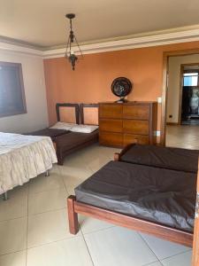 um quarto com duas camas e uma cómoda em Casa de frente pro mar em Arraial do Cabo em Arraial do Cabo