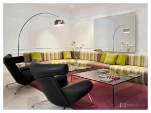 uma sala de estar com um sofá e uma mesa de vidro em Rochester Hotel M em Buenos Aires