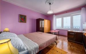 - une chambre violette avec un lit et une télévision dans l'établissement Apartment Crveni, à Umag