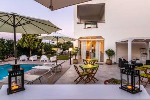 eine Terrasse mit Tischen und Stühlen und einem Pool in der Unterkunft Marricriu Camere Avola in Avola