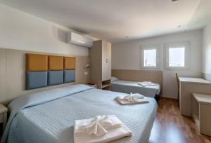 ein Schlafzimmer mit 2 Betten und Handtüchern darauf in der Unterkunft Hotel Stresa in Rimini