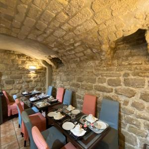 a dining room with tables and chairs and a stone wall at Austin's Saint Lazare Hotel in Paris