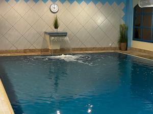 a swimming pool with a water fountain in a building at Ringhotel Fährhaus in Bad Bevensen