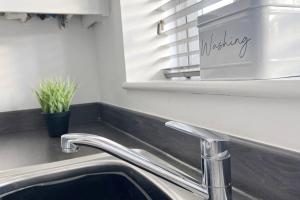 a sink in a kitchen with a mirror and a sink at Kingfisher House by Blue Skies Stays in Stockton-on-Tees