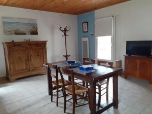 een eetkamer met een houten tafel en stoelen bij Maison vacances d'Oléron in La Brée-les-Bains