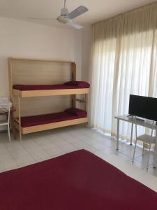 1 dormitorio con litera y escritorio con ordenador en Hotel Rivamare, en Cervia
