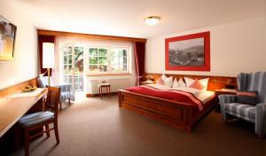 a bedroom with a bed and a desk and a window at Rebstock Waldulm in Kappelrodeck