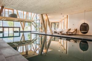 Großes Zimmer mit einem Tisch, Stühlen und einem Glasboden. in der Unterkunft Hotel Garberhof in Mals im Vinschgau