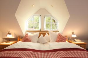 a bedroom with a large bed with red and white pillows at Rebstock Waldulm in Kappelrodeck