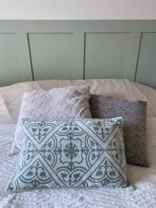 a bed with a pillow and two pillows on it at Majoliebriarde B&B - Chambre d hôtes proche Disneyland et Paris in Saint-Germain-sur-Morin