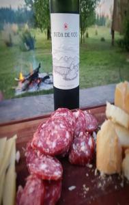 a bottle of wine and a bunch of meat and cheese at Buda de Uco Lodge in Tunuyán
