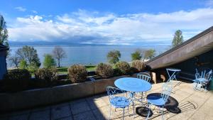 a patio with a table and chairs and a view of the water at Lakefront. Appartement pieds dans l'eau. View and direct access to the lake. in Anthy