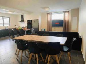 a dining room with a large wooden table and chairs at Villa Cap Méchant piscine chauffée avril à octobre in Saint-Joseph +4 photos