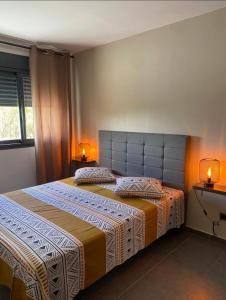 1 dormitorio con 2 camas y 2 lámparas en las mesas en Villa Cap Méchant piscine chauffée avril à octobre en Saint-Joseph