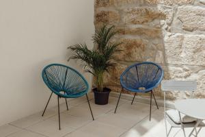 Dos sillas azules y una planta en una habitación en Courtyard Oporto Design Apartments by Vacationy, en Oporto