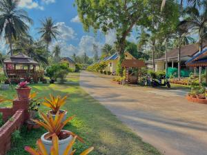 ulica w wiosce z domami i palmami w obiekcie Thungwua laen resort 