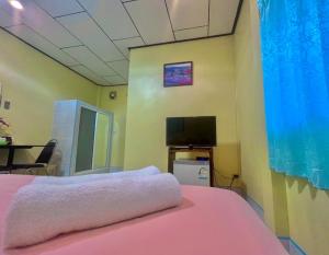 sypialnia z różowym łóżkiem i telewizorem z płaskim ekranem w obiekcie Thungwua laen resort 