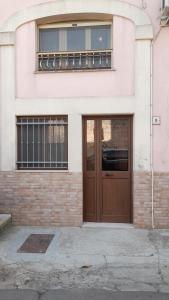 a building with a brown door and a window at CASA DELLE PEONIE in Ruffano