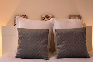 dwie poduszki siedzące na łóżku w obiekcie Résidence du Moulin Disneyland BMYGUEST w mieście Magny-le-Hongre
