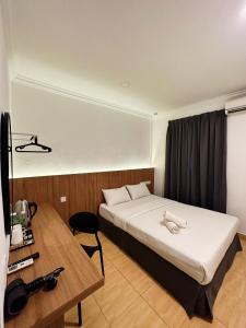a hotel room with a bed and a desk at Gemilang Hotel in Kota Kinabalu