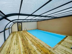 - une grande piscine dans une pièce dotée d'un plafond dans l'établissement Gîtes de la Mer - 4 Maisons avec piscine partagée, à Erquy