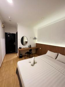 a bedroom with a bed and a desk with a mirror at Gemilang Hotel in Kota Kinabalu