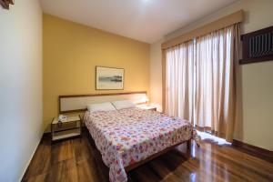 a hotel room with a bed and a window at Hotel Solaris in São Lourenço